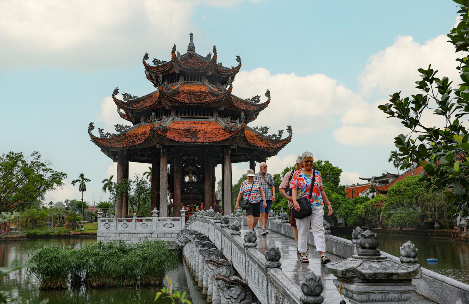 Travellers walking across a bridge in Nom Pagoda, Hanoi, Vietnam on a Bunnik Tour to Vietnam